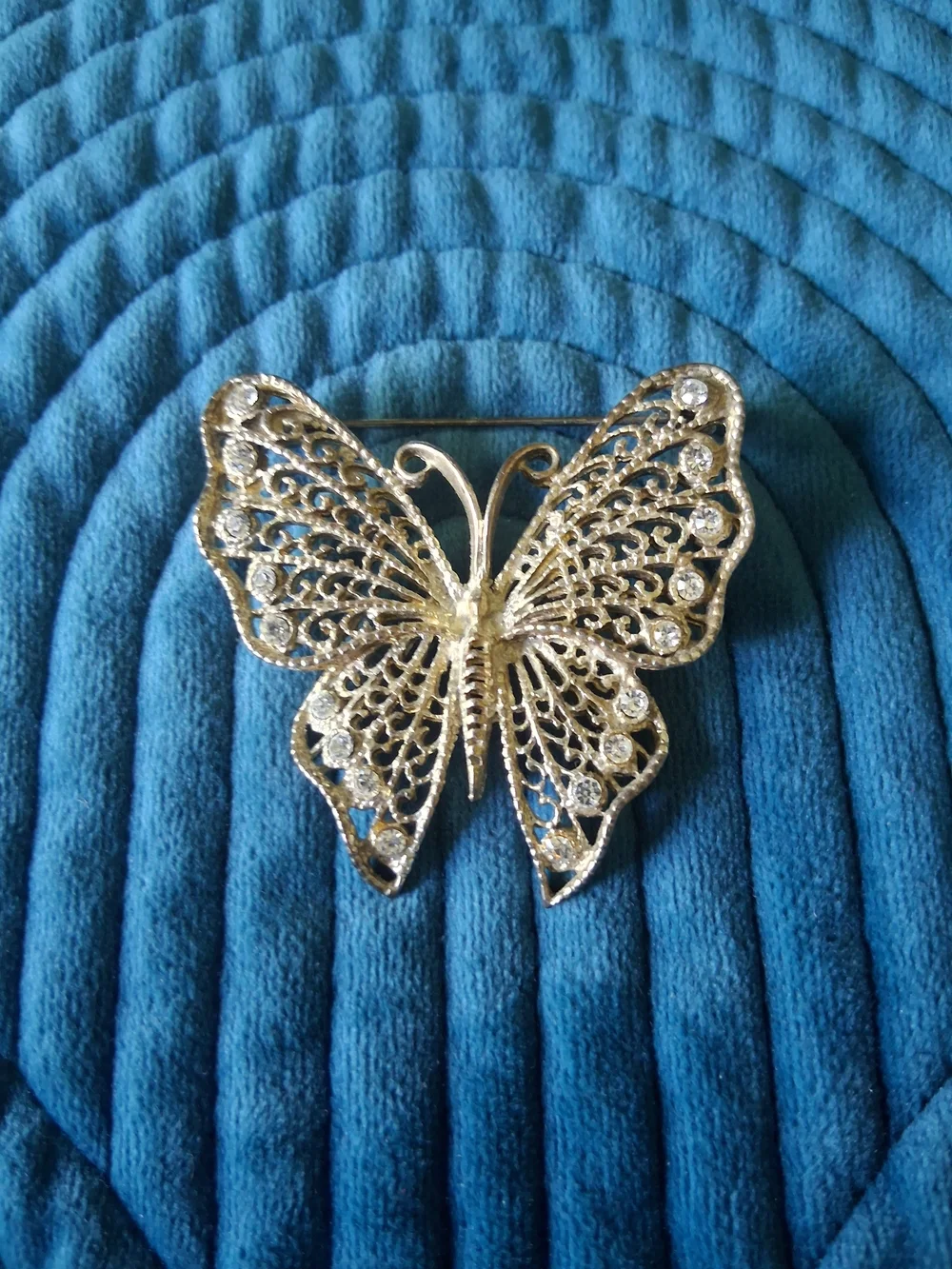 Vintage silver-tone filigree butterfly brooch adorned with rhinestones